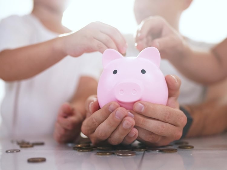 Family,With,Children,In,Their,Hands,Is,Holding,A,Piggy family putting money into a piggy bank