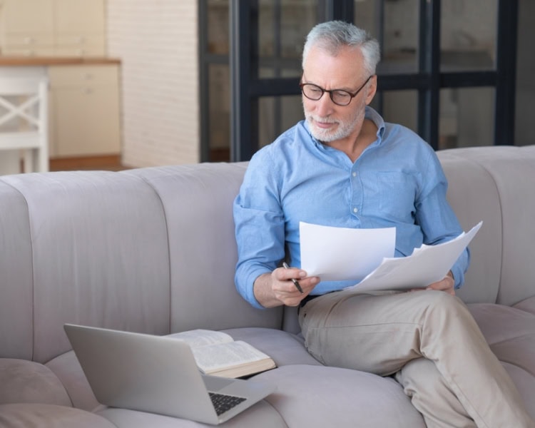 Working,Serious,Old,Senior,Elderly,Grandfather,Businessman,Paying,Domestic,Bills Retirement senior self employed man looking at paperwork and laptop